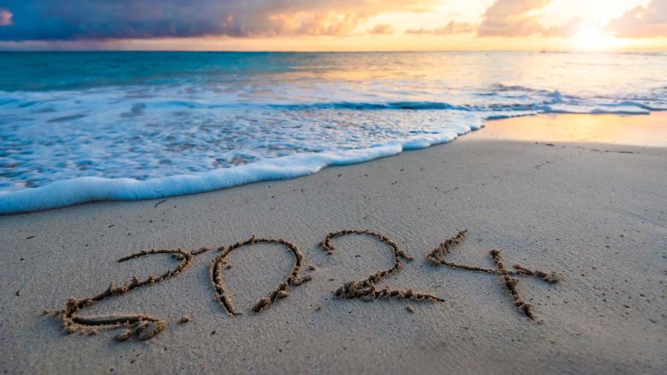 2024 year number handwritten on a sandy beach at sunrise